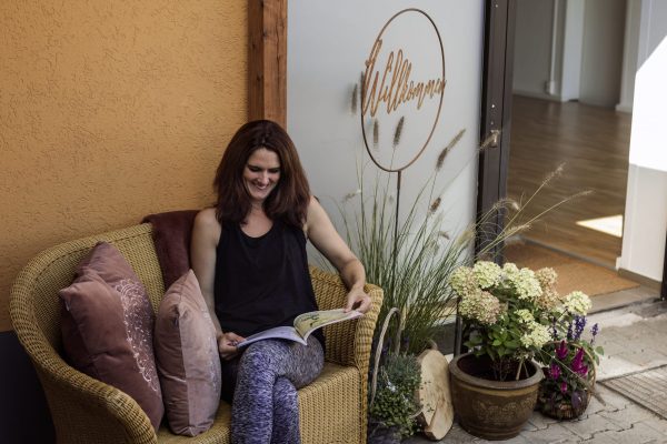 Inhaberin Simone Mülbert sitzt vor dem Yoga-Studio Inspirit in Wiesenbach